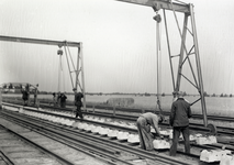167989 Afbeelding van het monteren van stukken spoor met betonnen dwarsliggers door wegwerkers van de N.S. op het ...